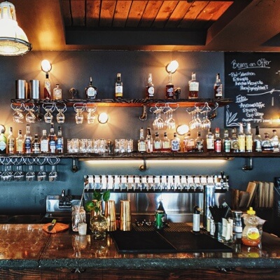 A clean bar with liquor bottles and beer taps